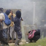 Des manifestants qui protestent contre la nouvelle loi sur la sécurité sociale, font face aux forces de l'ordre. KEYSTONE/EPA/CARLOS LEMOS